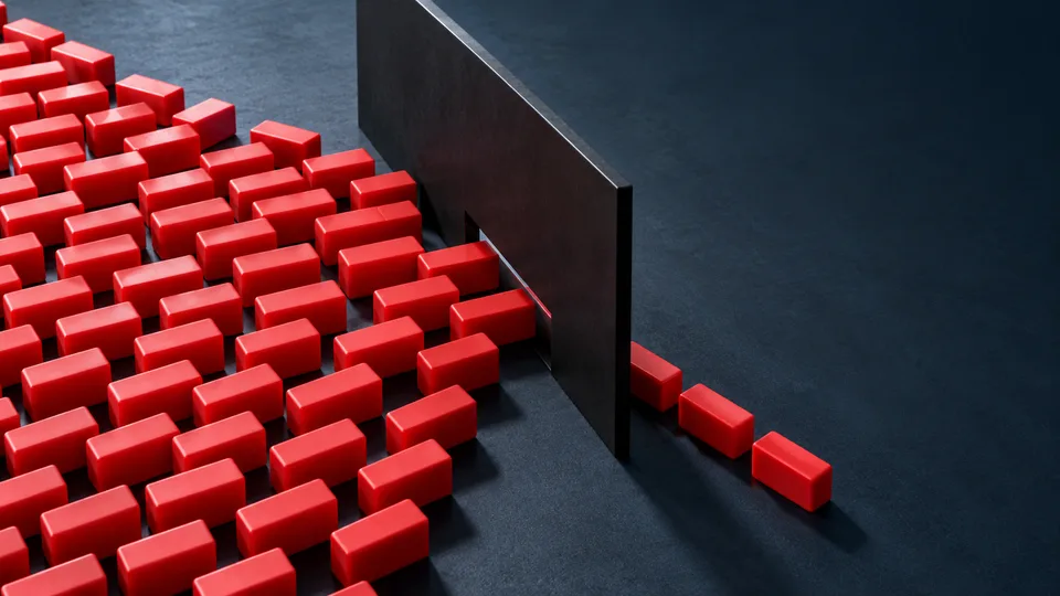 Red rectangular blocks converge at a narrow opening in a dark partition.